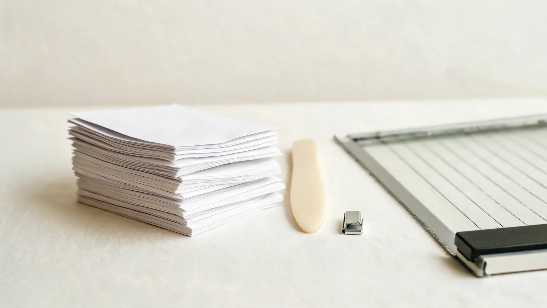 Bindery bench with folded sections, a bone folder and a guillotine edge